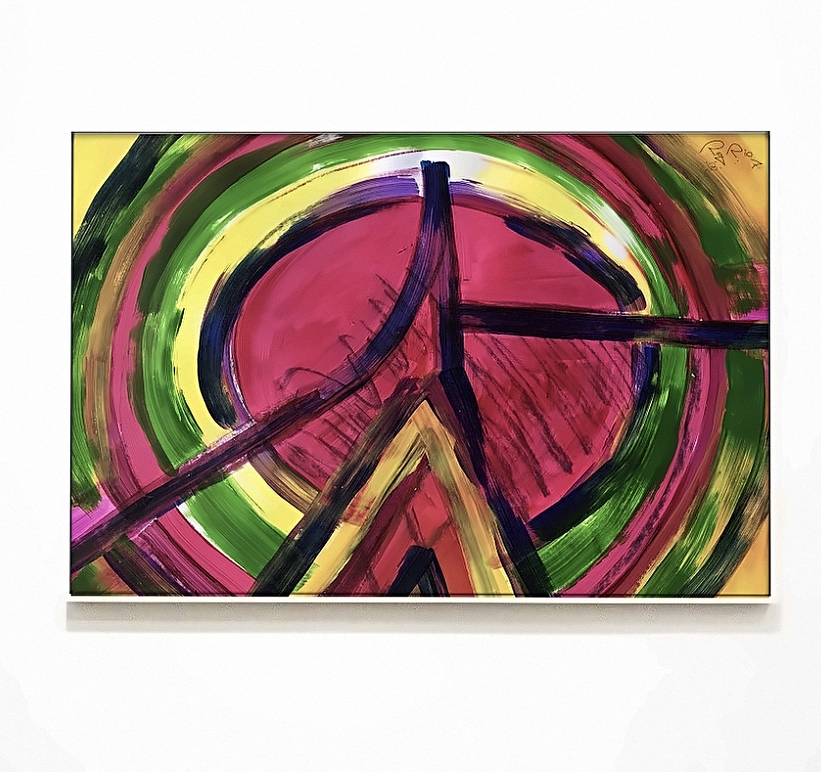 Quadro emoldurado em parede branca, com círculo rosa cercado por anéis verdes e amarelos e traços escuros em forma de cruz.