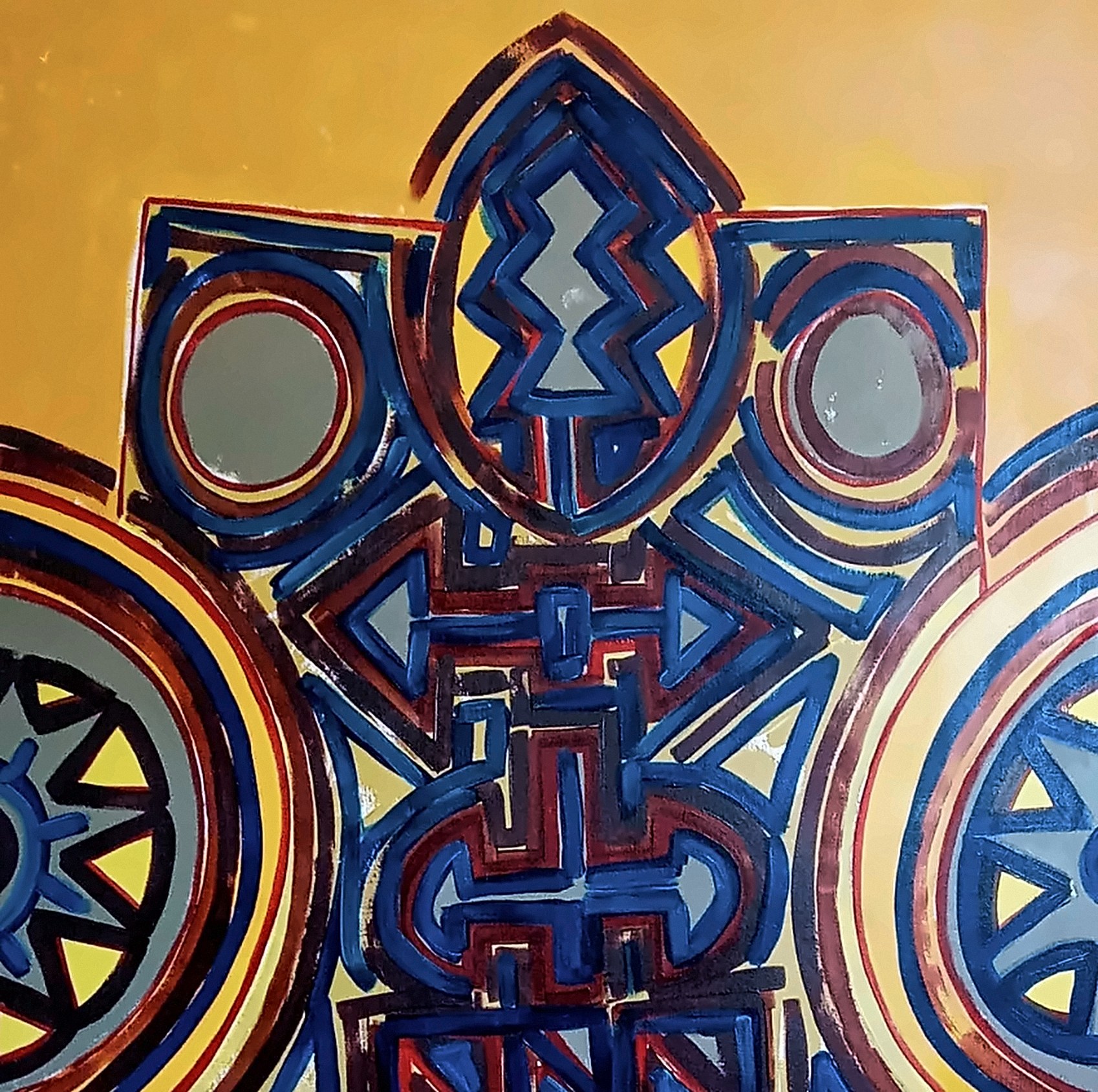 Quadro com formas simétricas em azul e vermelho-escuro sobre fundo amarelo-ouro, com círculos cinzentos e rodas com raios nas laterais.
