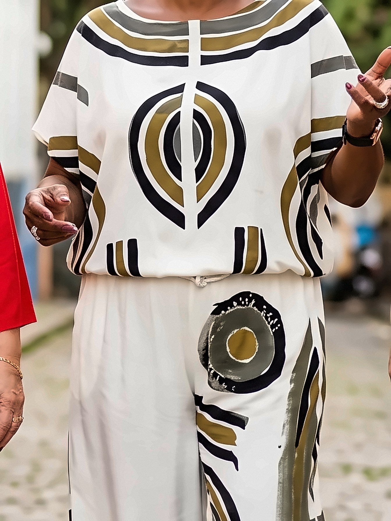 Conjunto de blusa e calça culote em tecido branco, com círculos e listras pintados à mão em preto, verde-oliva e cinza.