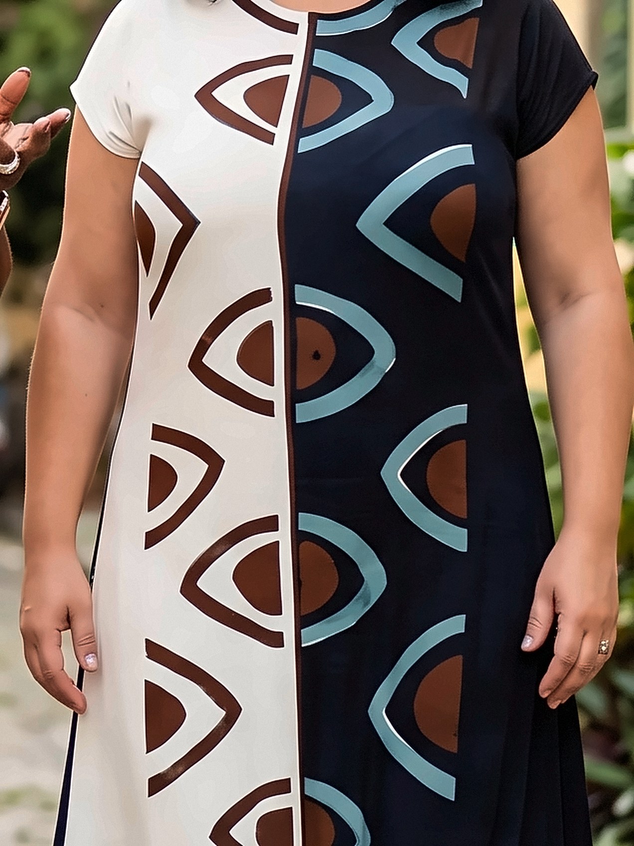Vestido longo dividido em branco e azul-marinho, com olhos pintados à mão em marrom e azul-acinzentado.